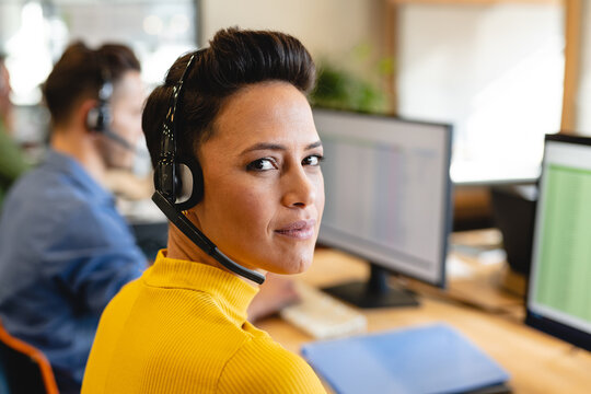Portrait of confident caucasian female customer service executive with headset in office