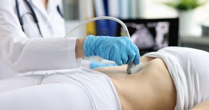 Ultrasound scanner device in hands of professional doctor examining patient early pregnancy