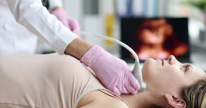 Doctor performs ultrasound of thyroid gland in clinic