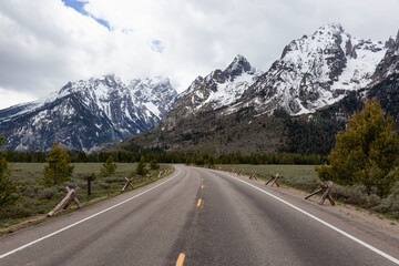 Scenic Road and Snowy Mountains in American Landscape. Spring Season. Grand Teton National Park. Wyoming, United States. Nature Background.