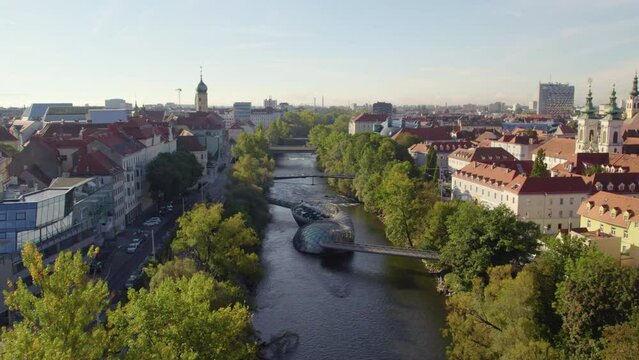 Scenic Graz city Austria aerial view following Mur river passing landmark Murinsel artificial floating island