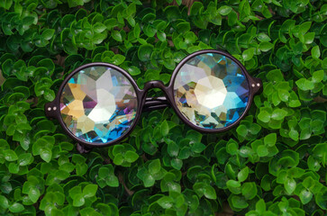glasses with kaleidoscope lenses on green grass