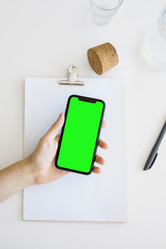 top view holding smart phone with green screen