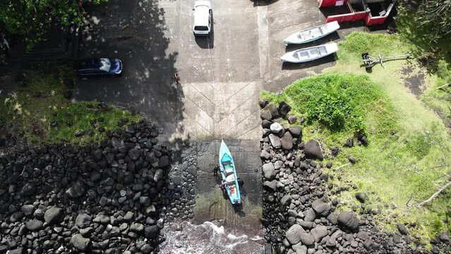 Top-down drone footage of people stowing a boat.