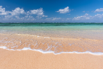 Fototapeta na wymiar Soft crystal clear wave of blue ocean on sandy beach. Selective focus.