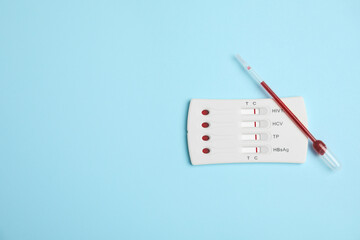 Fototapeta na wymiar Disposable express hepatitis test kit on light blue background, flat lay. Space for text