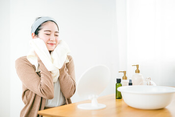 洗顔後にタオルで顔を拭く女性
