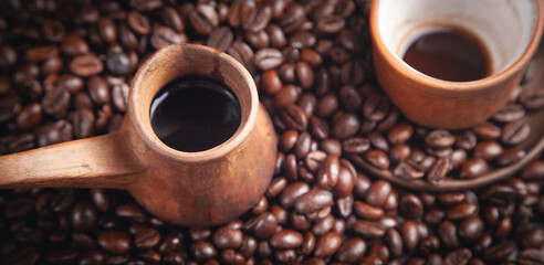  Clay coffee cup and pot on coffee beans.