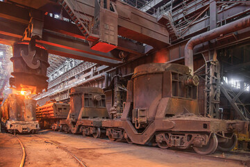Fototapeta premium Steel pouring from casting ladle into metal molds.