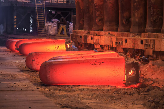 Hot red steel slabs in iron foundry workshop.