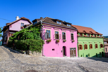 Fototapeta na wymiar Old colorful painted houses in the historical center of the Sighisoara citadel, in Transylvania (Transilvania) region of Romania, in a sunny summer day.