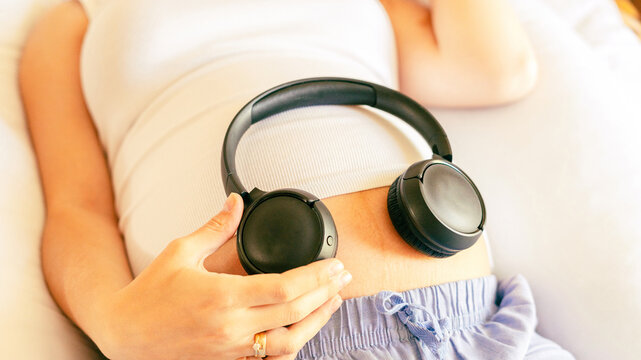 Pregnancy music woman listen. Pregnant woman listening to music. Mother belly listen headphones sound. Concept of pregnancy, maternity, expectation for baby birth.
