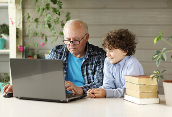 Grandfather and grandson study on the computer at home ,back to school