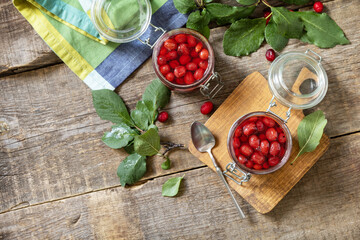 Homemade dogwood jam on a wooden background. Organic jam, healthy food. View from above. Copy space.