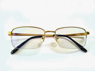 golden glasses with folded legs on a white background