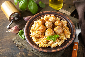 Italian  homemade kitchen. Italian fusilli pasta gluten freewith meat balls in tomato sauce and basil on rustic table. Copy space.