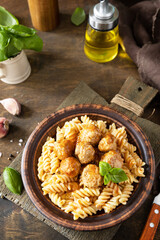 Italian  homemade kitchen. Italian fusilli pasta gluten freewith meat balls in tomato sauce and basil on rustic table. Copy space.