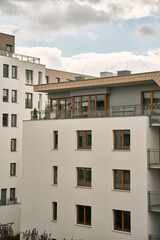 Fototapeta premium Modern apartment building with green zones below. Concept of an ecofriendly real estate investment in Europe