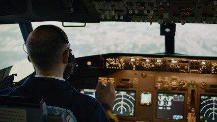 Airplane pilot flying aircraft fixing altitude and longitude level, using plane dashboard command to takeoff. Switching power engine and navigation on control panel. Handheld shot. - Powered by Adobe