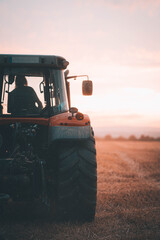 Traktor auf romantischem Feld macht Heuballen