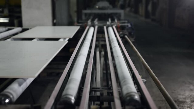 Factory for the production of ceramic tiles and porcelain tiles. Automatic conveyor in the workshop.