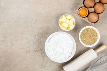 Utensils and ingredients for making cakes, cookies, cupcakes. Baking ingredients - flour, sugar, butter, eggs, rolling pin, whisk. Top view, copy space.