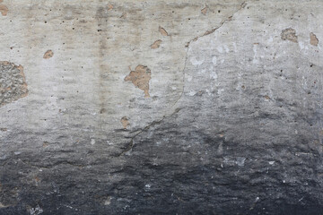 A plaster old wall with beautiful grunge texture. A weathered wall background in shades of grey and white.