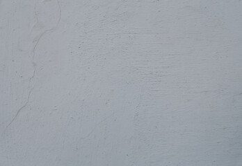 An old cement painted wall, white grey abstract background. A scratched concrete wall texture with...