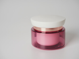 Pink lip balm in jar on a white background