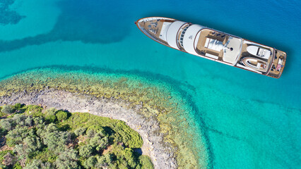 Aerial drone top down photo of luxury yacht with wooden deck anchored in paradise exotic emerald...