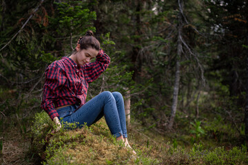 Naklejka na ściany i meble Attractive young girl in hipster clothes inforest on moss posing