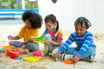 Group of Diversity children kid playing sand with toy together at playground in the park on summer vacation. Little child boy and girl friends enjoy and fun outdoor activity playing together at school