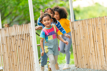 Group of Diversity little child boy and girl friends playing and running together at playground in the park. Happy children kid enjoy and fun outdoor activity learning and playing together at school