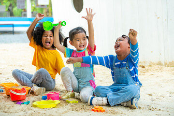 Group of Diversity children kid playing sand with toy together at playground in the park on summer vacation. Little child boy and girl friends enjoy and fun outdoor activity playing together at school