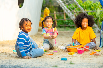 Group of Diversity children kid playing sand with toy together at playground in the park on summer vacation. Little child boy and girl friends enjoy and fun outdoor activity playing together at school