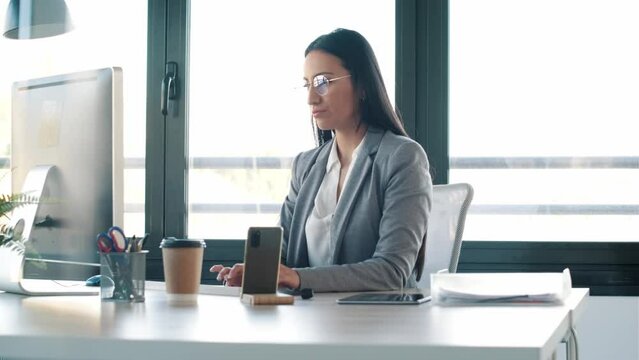 Video of concentrated young business woman working with computer in the office.