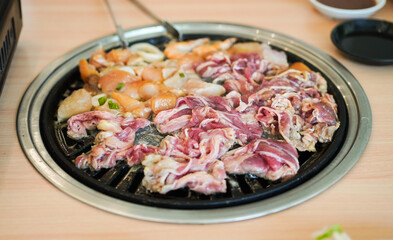 Raw beef slice for barbecue japanese style, yakiniku. Meats are being cooked on stove in a japanese restaurant.