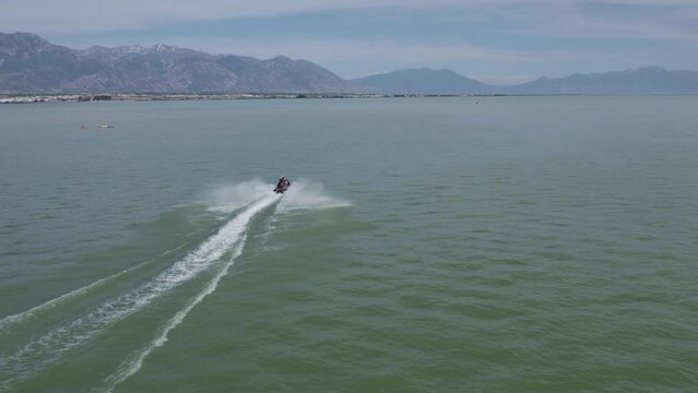 Jet Ski Sea Doo Rider on Lake with Beautiful Mountainous Background, Aerial