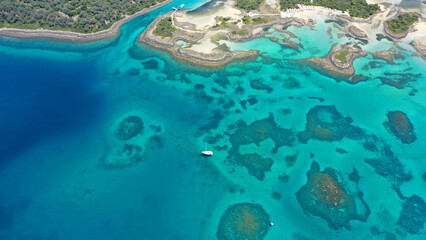 Aerial drone photo of tropical exotic volcanic island complex of Lihadonisia  forming a blue lagoon and small islet of Monolia with turquoise clear organised beach, north Evia island, Greece