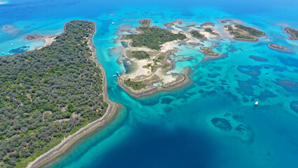 Aerial drone photo of tropical exotic volcanic island complex of Lihadonisia  forming a blue lagoon and small islet of Monolia with turquoise clear organised beach, north Evia island, Greece