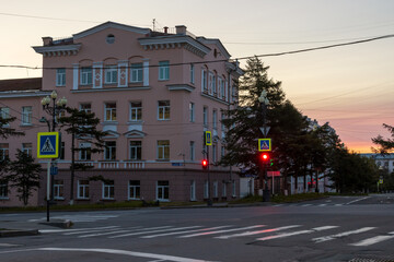 Fototapeta premium Morning cityscape. View of empty streets, crossroads, crosswalk and building. Red traffic light. City of Magadan, Magadan region, Far East of Russia.