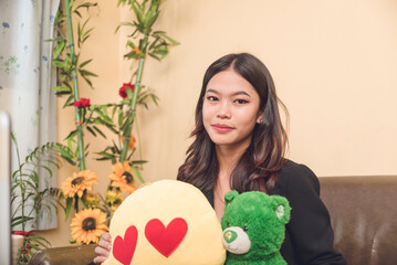 A pretty and young asian professional holding stuffed toys from an admirer or boyfriend.