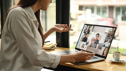 Cropped shot young business woman having online video call on laptop while sitting in modern...