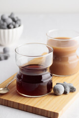 Cups of fresh coffee and a liquorice candies on white table