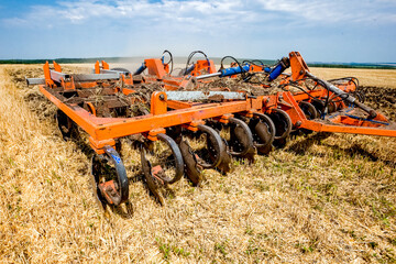 Tractor working in wheat field. Agriculture background. Harvest season