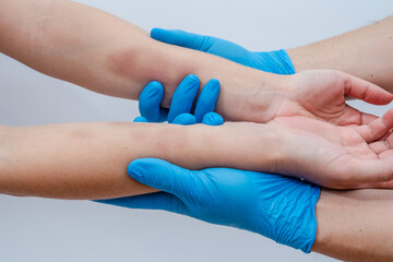 Doctor palpates and examines bruises on woman's arms isolated