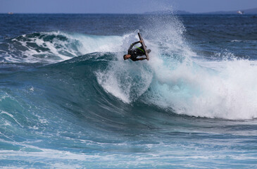 Obraz premium PUERTO DE SANTIAGO, TENERIFE - JUNE 2022: surfer riding the waves in Tenerife