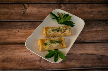 Pancakes on plate with condensed milk and greenery