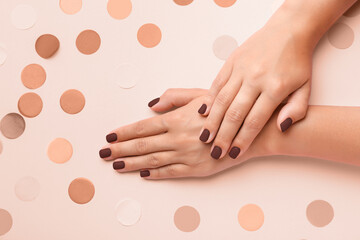 Female hands with beautiful brown manicure on light background