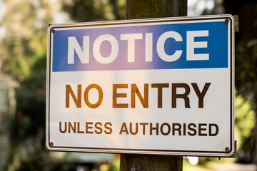 Notice. No entry unless authorised sign on a wooden pole